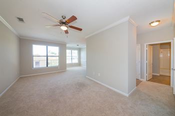 A room with a ceiling fan and carpeted floor.